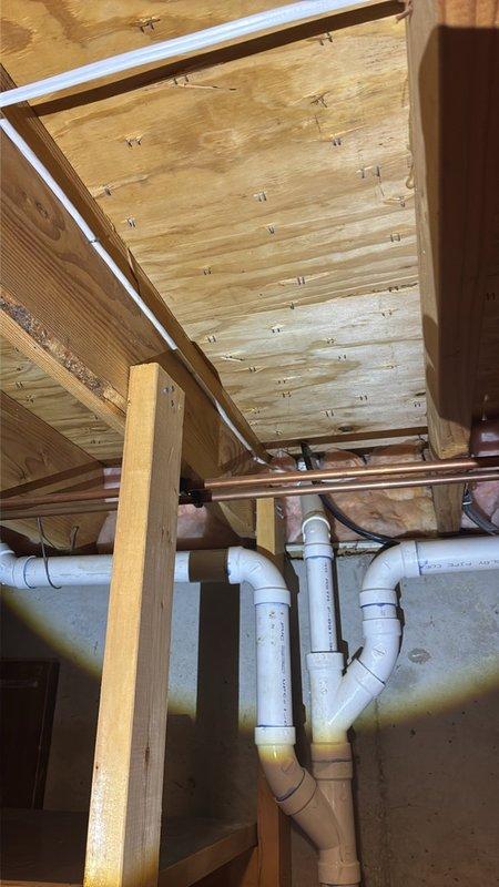 Performed an on-site estimate for installing a new gas line from the basement to the kitchen. Inspected the basement joist space and existing black iron gas piping, noting adjacent copper supply lines, PVC drain piping, ductwork, and electrical cabling that will affect pipe routing and joist penetrations. Documented existing conditions with photos and determined the routing path for the proposed run.