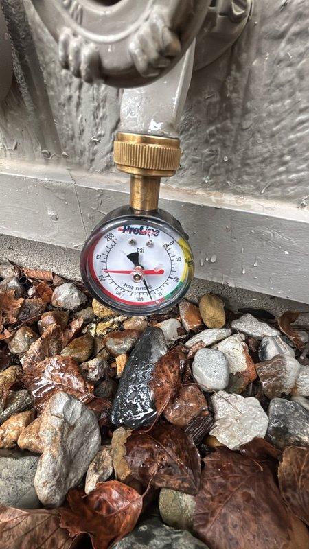 Performed a scheduled plumbing maintenance visit including a tankless water heater flush to remove mineral scale and sediment from the heat exchanger and restore efficient operation. Verified water pressure at the exterior hose bib using a pressure gauge, with readings within the normal 50–60 psi range, and inspected the copper supply piping, pressure regulator, and isolation valves at the main utility area, finding all components in serviceable condition.