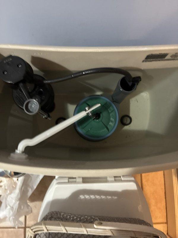 Inspected the toilet tank assembly, including the fill valve, overflow tube, flush valve, and flush lever, and serviced the components to restore proper operation. Also inspected the exposed copper supply lines in the crawl space, noting oxidation and mineral buildup at the soldered joints and elbow fittings for future monitoring.