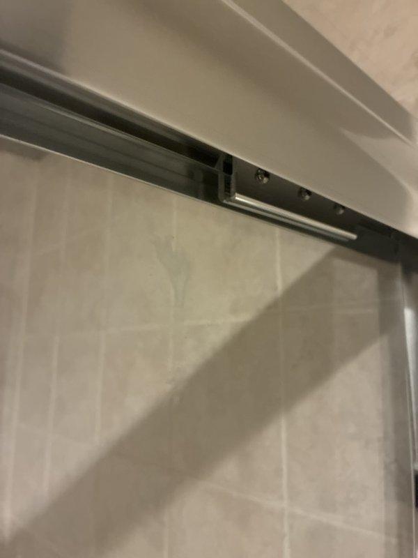 Reinstalled and secured the previously removed sliding glass shower door panels and side panels, seating the door hangers in the top track and verifying all fasteners were tight. Confirmed smooth roller operation, proper alignment, and a stable, safe enclosure with no visible damage to the glass, frame, or tile.