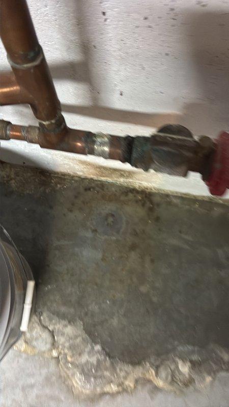 Located and inspected a slow leak at a corroded copper-to-galvanized pipe connection in the unfinished basement, where verdigris buildup and moisture residue at the soldered joint indicated the failure point. Isolated the water supply, repaired the leaking connection, and restored service, then verified the joint was dry and leak-free under pressure.