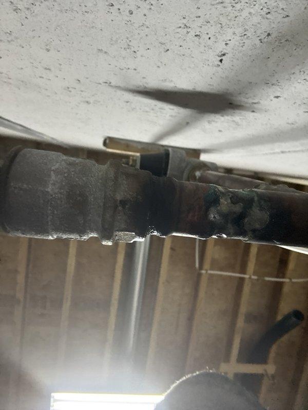 Located and inspected a slow leak at a corroded copper-to-galvanized pipe connection in the unfinished basement, where verdigris buildup and moisture residue at the soldered joint indicated the failure point. Isolated the water supply, repaired the leaking connection, and restored service, then verified the joint was dry and leak-free under pressure.