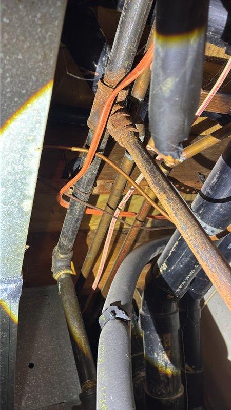 Performed a plumbing estimate for gas line replacement and inspected the existing piping in the attic/utility chase area. Found heavily corroded iron supply piping with flaking rust at threaded fittings, tarnished copper lines with oxidation, and deteriorated, split pipe insulation with taped repairs. The existing system is still operational, and the findings were documented with photos to support the recommended piping replacement scope.