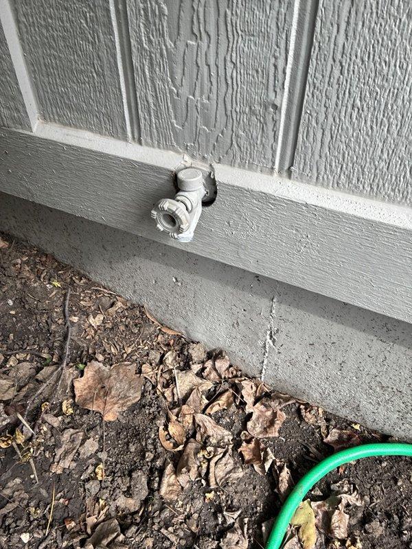 Responded to a callback regarding a reported damaged exterior hose bib and inspected the spigot, which was found to be intact, securely mounted, and free of leaks, frost damage, or corrosion. Loose hardware, including a washer and small fitting, was found on the ground near the fixture, and the garden hose was reconnected to verify proper operation.