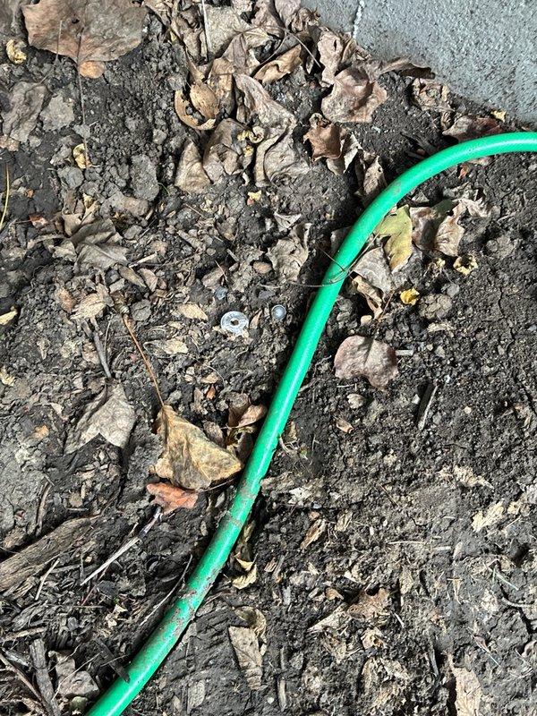 Responded to a callback regarding a reported damaged exterior hose bib and inspected the spigot, which was found to be intact, securely mounted, and free of leaks, frost damage, or corrosion. Loose hardware, including a washer and small fitting, was found on the ground near the fixture, and the garden hose was reconnected to verify proper operation.