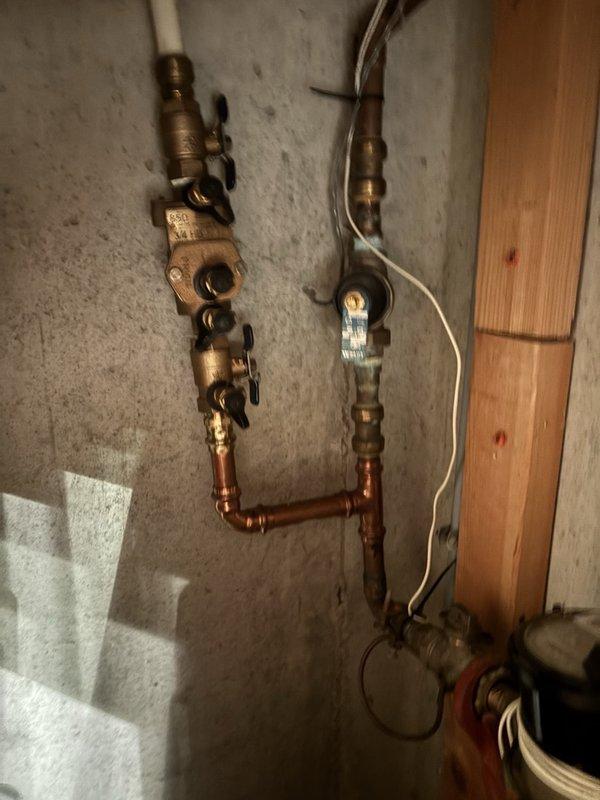 Performed a comprehensive plumbing inspection of the water supply system, including the exterior hose bib with attached pressure gauge and the brass backflow preventer assembly with associated copper supply piping and valves, noting no signs of freezing or heavy corrosion. Flushed the tankless water heater to remove mineral and sediment buildup and restore efficient operation.