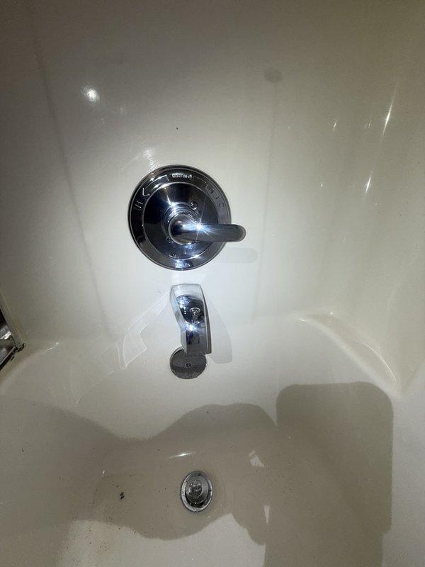 Installed the correct trim kit on the existing single-lever shower valve, including a chrome trim plate and lever handle, and verified proper fit and seating against the wall. Confirmed the tub spout with diverter, showerhead, and drain are in place and show no visible damage, corrosion, or buildup.