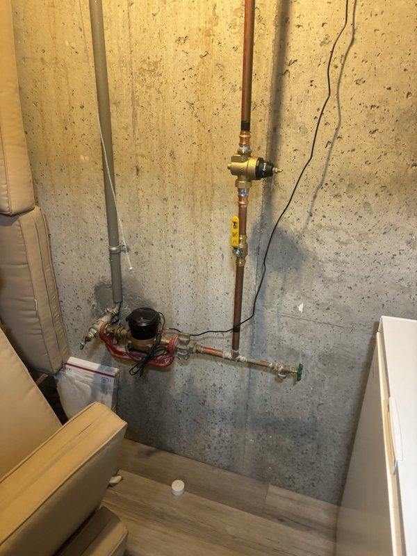 Performed a whole-home plumbing inspection, including a visual assessment of the basement water service entry assembly comprising the copper supply piping, pressure-reducing valve, ball valve, hose bib, and water meter connection. Found no active leaks, corrosion, or visible damage on the inspected piping and valves. Noted the aged main shut-off valve and the second-floor sink faucet flex hoses as known items pending replacement.
