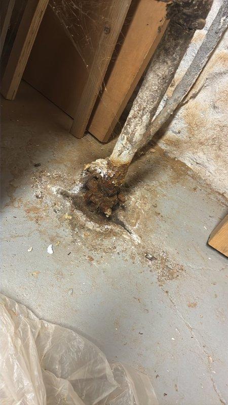 Performed an on-site assessment and estimate for boiler/water heater service, documenting the existing piping and valve assembly with photographs. Inspection revealed severe corrosion and heavy mineral scale on the vertical supply piping, elbow, and gate valve, with active rust staining and calcium deposits at the pipe base indicating long-term moisture exposure and probable seepage at the floor connection. Findings support replacement of the deteriorated piping, fittings, and isolation valve as part of the recommended scope of work.