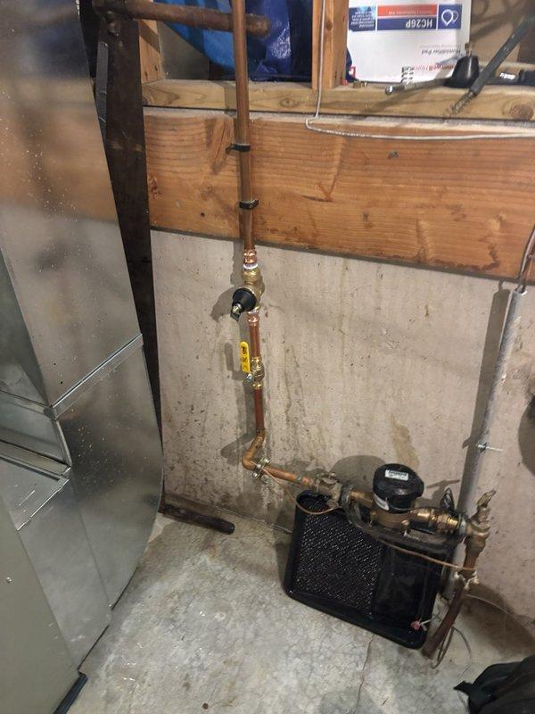 Repaired a leaking shower drain by accessing the PVC drain assembly from below through the existing garage ceiling opening. Inspected the P-trap, vertical riser, and flanged drain fitting seated in the subfloor, then serviced the connections and sealing at the drain flange to eliminate the leak.