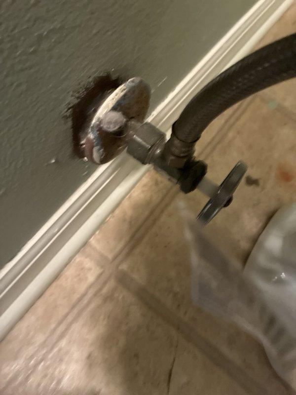 Performed annual plumbing maintenance including a flush of the tanked water heater to remove sediment buildup and restore heating efficiency. Inspected the surrounding PVC drain piping and cleanout fitting, noting staining and moisture residue on the adjacent floor, and checked the angle stop valve and braided supply line, observing an aged, discolored escutcheon and deteriorated drywall opening at the wall penetration. Recommend monitoring the noted areas for leaks and scheduling repair of the worn valve escutcheon and wall opening as needed.