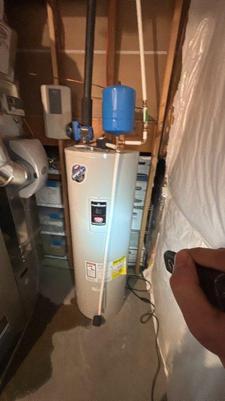 Responded to a leak at the base of an electric tank-style water heater and inspected the unit, including the expansion tank, supply piping, fittings, and surrounding connections, to identify the source of the leak. Performed the necessary repairs to correct the leak, then verified the system was holding pressure with no further moisture at the base of the tank.