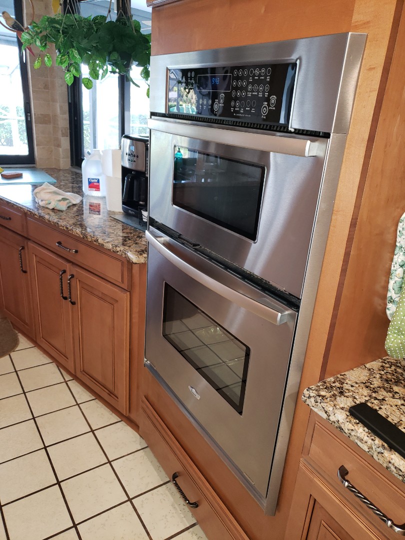 THE TECHNICIAN IS REPAIRING A WHIRLPOOL MICROWAVE 