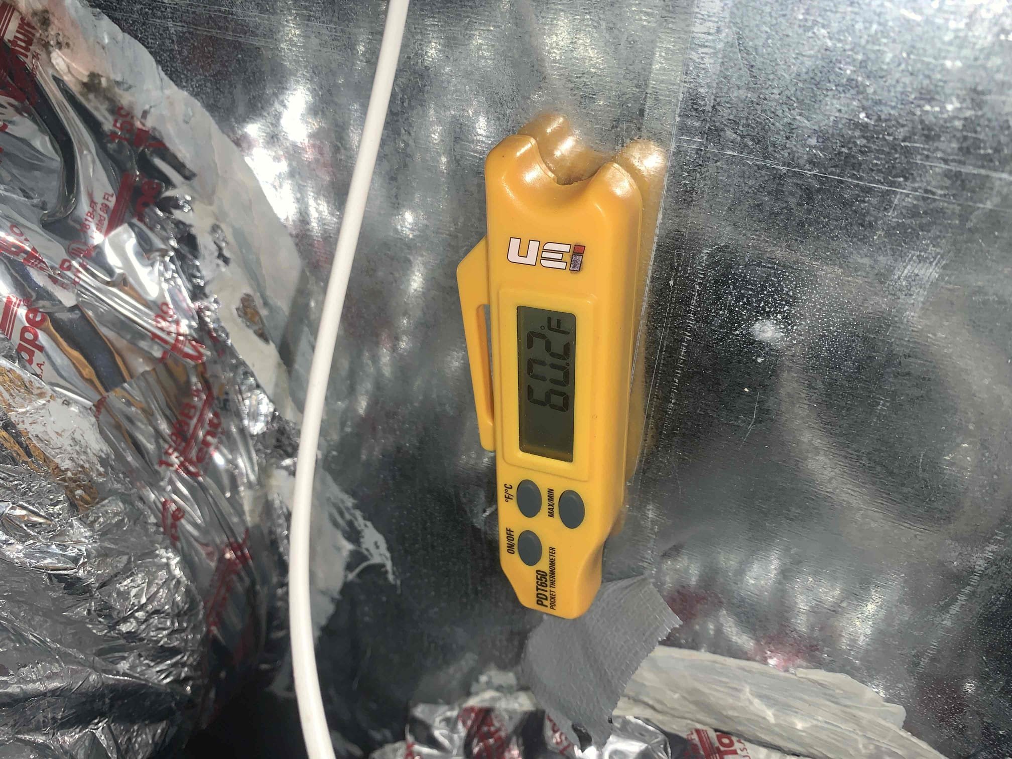 Arrived on site, homeowner complained of unit not keeping up with the set temperature. indoor temperature around 76° while the set point was 74. I waited for a little bit to see if the unit would kick on by itself which it did, and immediately shut itself off on a float switch error. Tested drain line and found water not draining and going up the service port after the P-trap. I blew out the drain line with nitrogen and then disassembled the drain line Connection to the front bathroom sink. I found a large amount of sludge blocking the half inch nipple elbow connecting to the bathroom drain.  Reassembled drain line and blew out with nitrogen again and tested with several gallons of water. Drain line is draining properly at this time. Reviewed refrigerant pressures and temperature split from supply to return and found no issues. I also found the scheduling enabled on the thermostat. Homeowner had not set up, scheduling to his comfort on the app, so I disabled the scheduling so that the 