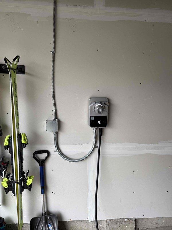 Successfully installed a ChargePoint Home Flex EV charging station for customer's Tesla Model Y. Unit was properly mounted on the wall, wired to an existing 240V circuit, and tested for functionality. Confirmed proper operation with green indicator lights illuminated and charging cable properly secured in holster.