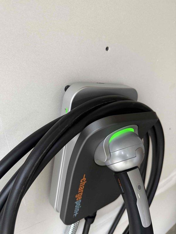 Successfully installed a ChargePoint Home Flex EV charging station for customer's Tesla Model Y. Unit was properly mounted on the wall, wired to an existing 240V circuit, and tested for functionality. Confirmed proper operation with green indicator lights illuminated and charging cable properly secured in holster.
