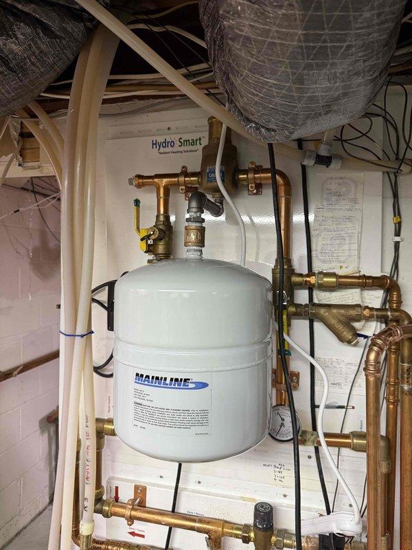 Successfully installed a Navien NCB240/110H combi system with primary manifold, replacing the existing unit. Connected all boiler and domestic water lines, added an expansion tank to the in-floor heat system, and installed anti-scale protection. Replaced the existing 3" cell core venting with code-compliant 3" solid core for both intake and exhaust, and confirmed proper system operation with no leaks present.