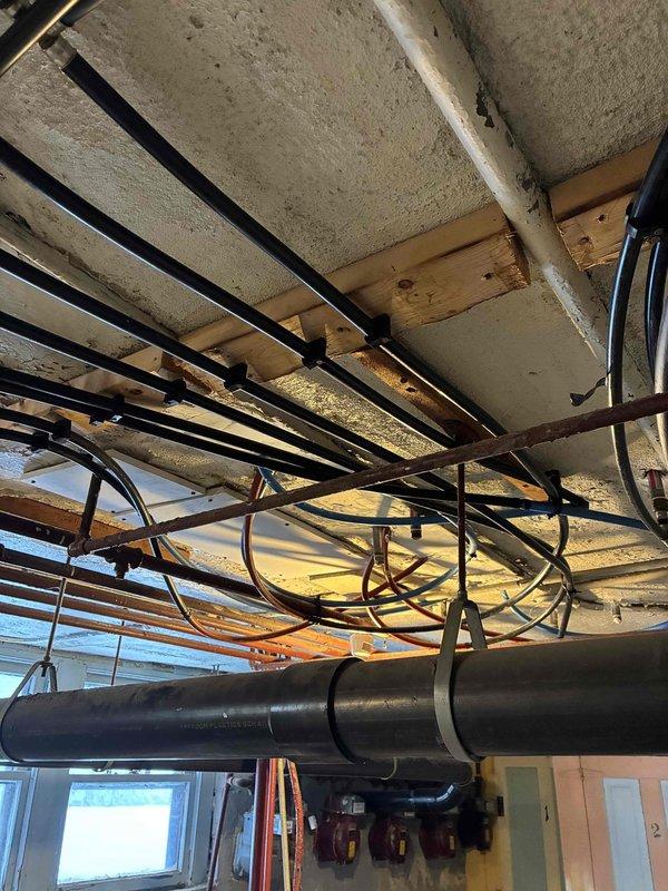 Conducted inspection of kitchen faucet with low hot water pressure issue. Upon assessment, determined problem was not with the faucet (previously replaced by another technician) but traced to restrictions in the hot water supply line. Inspected basement mechanical room containing boiler system and water heater, examined exposed plumbing infrastructure and identified mineral buildup in hot water supply pipes contributing to pressure loss. Cleared obstruction and restored proper hot water pressure to kitchen faucet.