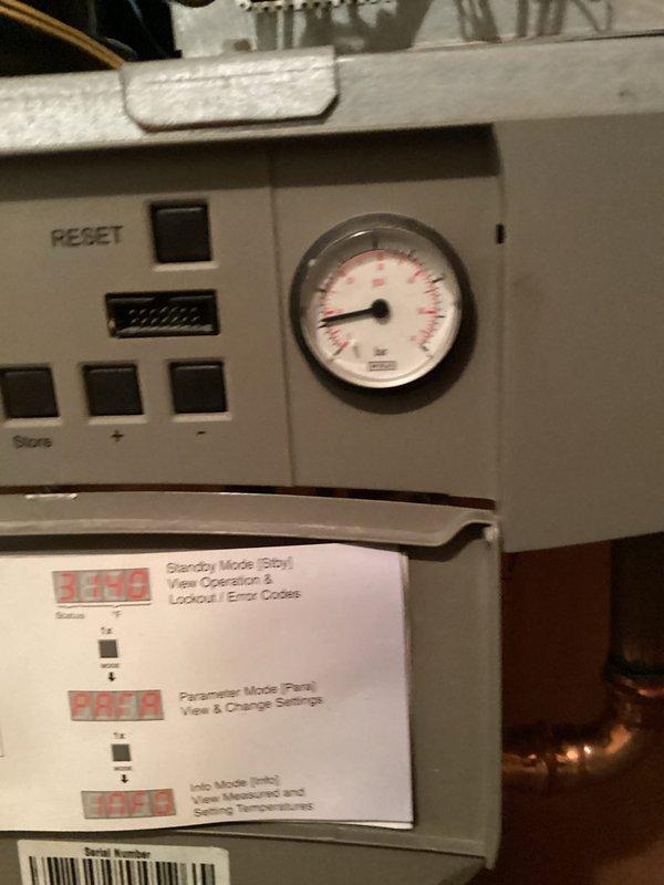 Responded to service call for non-functioning Triangle Tube boiler displaying error code E28. Upon inspection, found control panel inoperative with system in standby mode. Diagnosed issue with Honeywell control module and wiring connections. Reset system, checked pressure gauge readings, and confirmed proper operation of digital display interface. Located replacement parts needed to resolve fault code E28. System now operational with house temperature returning to normal range.