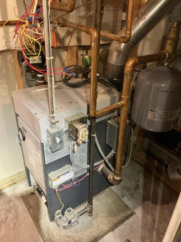 Performed maintenance service on residential heating system including inspection and cleaning of high-efficiency boiler, gas fireplace, and garage electric baseboard heater per prepaid maintenance agreement. System components inspected include boiler control panel, copper distribution piping, valves, expansion tank, and electrical connections. All systems operating within normal parameters with no issues identified.