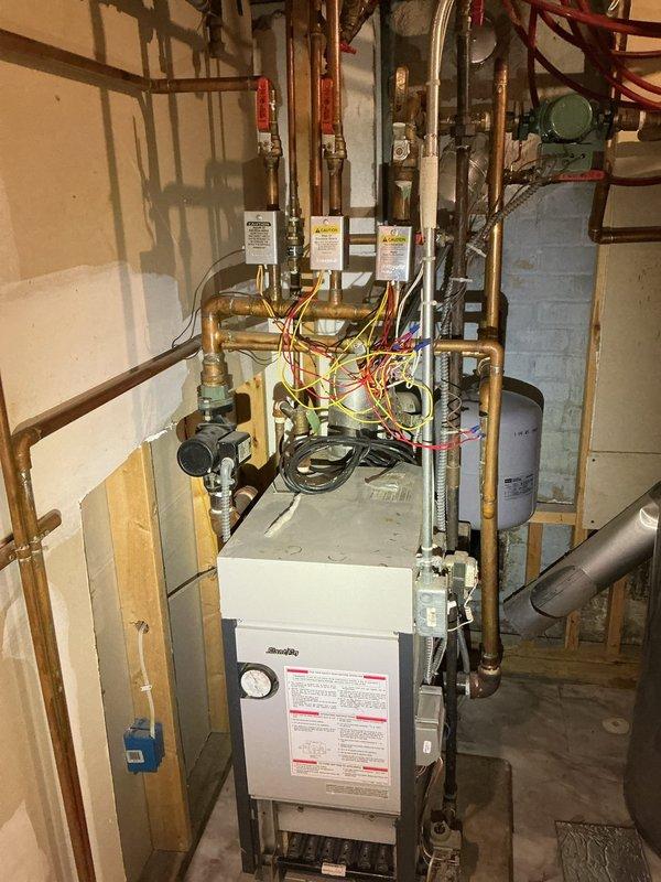 Performed maintenance service on residential heating system including inspection and cleaning of high-efficiency boiler, gas fireplace, and garage electric baseboard heater per prepaid maintenance agreement. System components inspected include boiler control panel, copper distribution piping, valves, expansion tank, and electrical connections. All systems operating within normal parameters with no issues identified.
