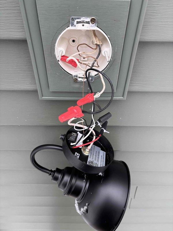 Completed final siding electrical work, installing two exterior light fixtures and one outlet on the residence. Replaced damaged/corroded outlet cover and properly wired new outdoor light fixture to existing junction box, ensuring secure connections with appropriate wire nuts.