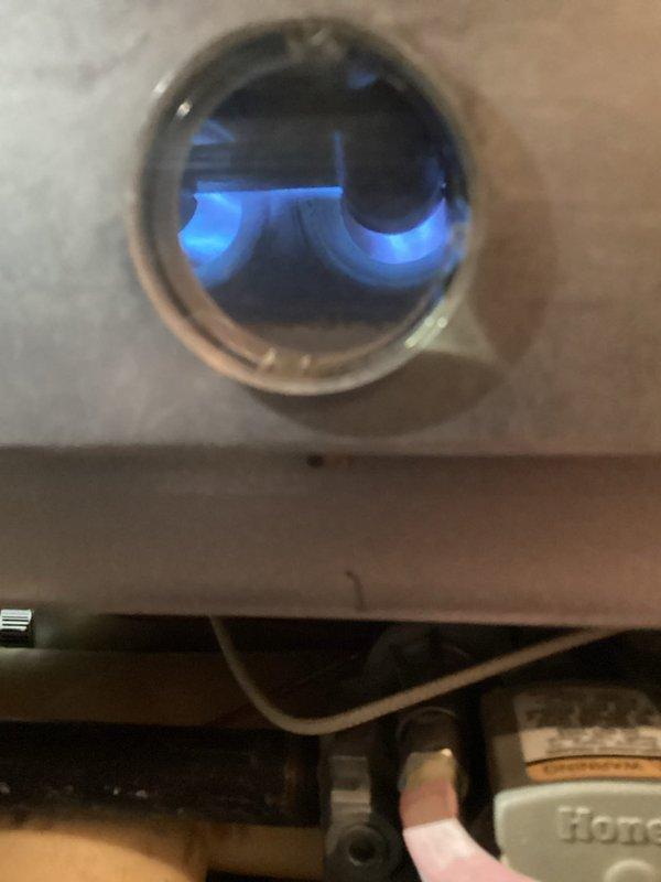 Responded to customer's complaint of furnace underperforming (set at 67°F but only reaching 64°F). Diagnostic testing revealed multiple component failures affecting system efficiency. Observed proper blue flame pattern through inspection port but insufficient heating capacity. Recommended and performed complete system replacement as repair of failing components would not restore proper functionality.