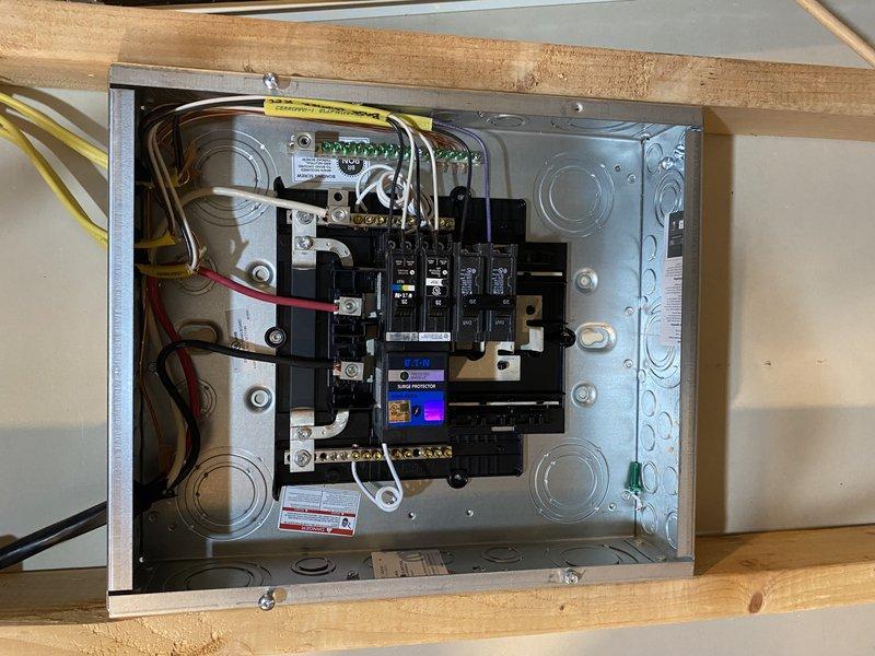 Completed installation of a 60-amp sub-panel in the unfinished basement mechanical room with two 120V 15-amp tandem breakers in the main 150-amp Square D QO panel. Installed whole house surge protector and two 120V GFCI devices in basement. Successfully fished 240V circuit through unfinished areas, terminating in junction box near garage fireplace bump-out with surface-mounted conduit protection to back wall. Hardwired Xcel-supplied EV charger with 60-amp protection for 48-amp output capacity.