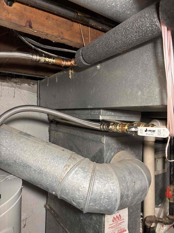 Replaced existing power vent water heater with new Bradford White G2 50-Gallon Electric Hybrid Heat Pump Water Heater (M# RE2HP5010-1NCTT). Relocated unit for improved accessibility near exterior wall and electrical panel, disconnected gas line and capped, installed new water isolation shut-off valves to code, and connected condensate line to floor drain in laundry room. System tested with no leaks detected.