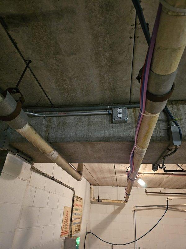 Installed new electrical outlet near car wash in parking garage as requested by client. Mounted junction box on concrete block wall, ran conduit from existing supply to new outlet location, and connected to power source. Verified proper functionality of outlet upon completion.