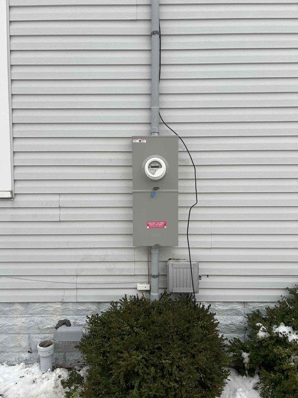 Completed a 200 amp overhead service upgrade, installing new meter enclosure, service mast, and weatherhead at existing outdoor location. Installed new 40-space main electrical panel in basement with all new circuit breakers while maintaining existing circuit protection, along with whole home surge protection and proper grounding via dual 8' ground rods. Also installed 30 amp dedicated wiring with junction box for water heater in unfinished basement ceiling area.