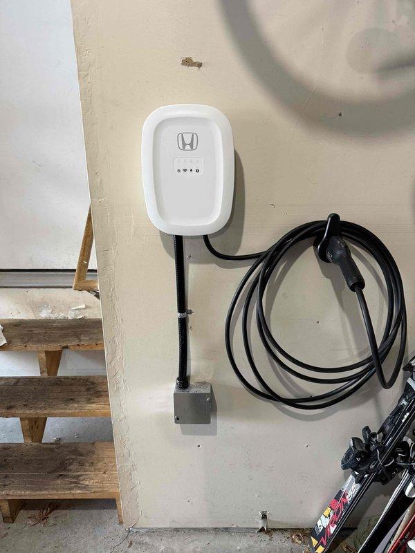 Completed the installation of Electrum supplied Emporia EV charger, replacing the existing Enel X Juicebox as specified. Verified proper electrical connection to the 60A breaker in the main panel and confirmed charging functionality with customer's Honda EV. Documented installation with photographs of completed charger mounting, cable management, and electrical panel connections.