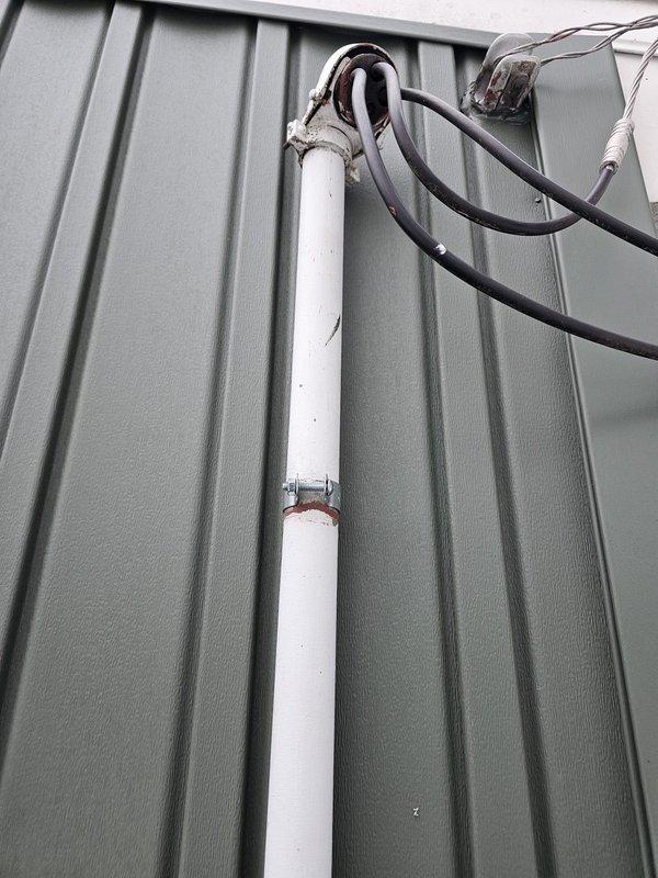 Completed inspection corrections on service mast by installing proper strapping to secure it against the green metal siding. Verified all connections where cables enter the weatherhead and ensured proper installation of the two lights and outlet on the exterior of the house as required for the siding final.