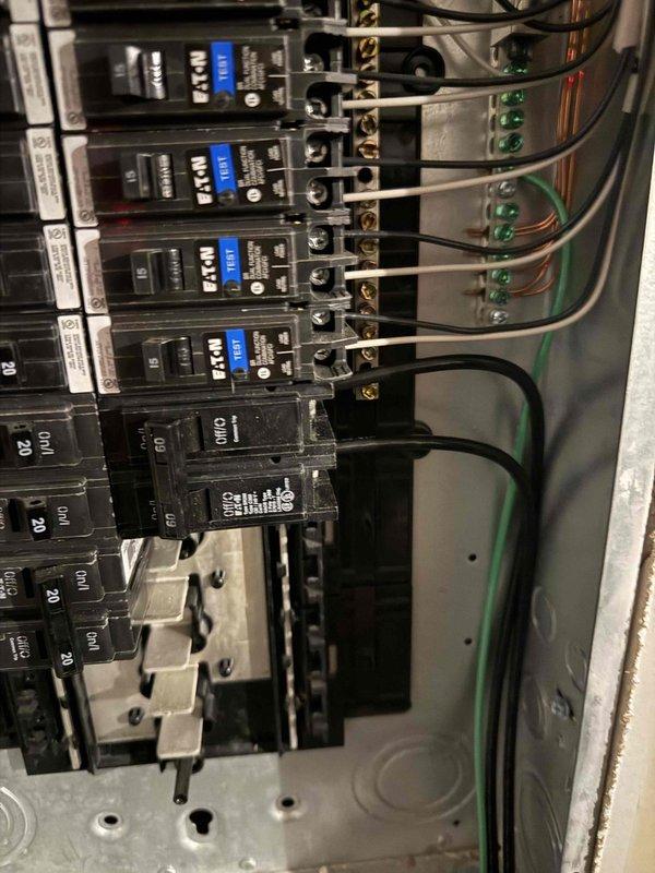 Successfully installed and configured customer-supplied Tesla EV charger in garage adjacent to 150A Eaton BR panel. Completed hardwiring with 60A circuit protection for 48A output capability, using surface-mounted conduit for wire protection. Verified proper operation of charging system with green indicator light confirming operational status.