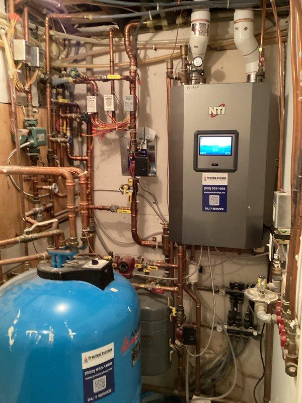 Conducted inspection of residential hydronic heating system with NTI boiler to address cold room issue. Examined entire installation including copper piping network, expansion tank, pressure gauge assembly, and control components. No immediate issues identified requiring repair at this time.