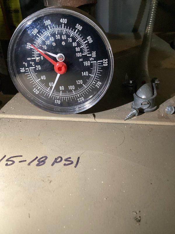 Responded to service call for boiler pressure issues. Diagnosed trapped air in system causing elevated pressure readings (gauge showing above normal 15-18 PSI operating range). Performed complete system purge across all three floors to release trapped air and restore proper pressure levels.