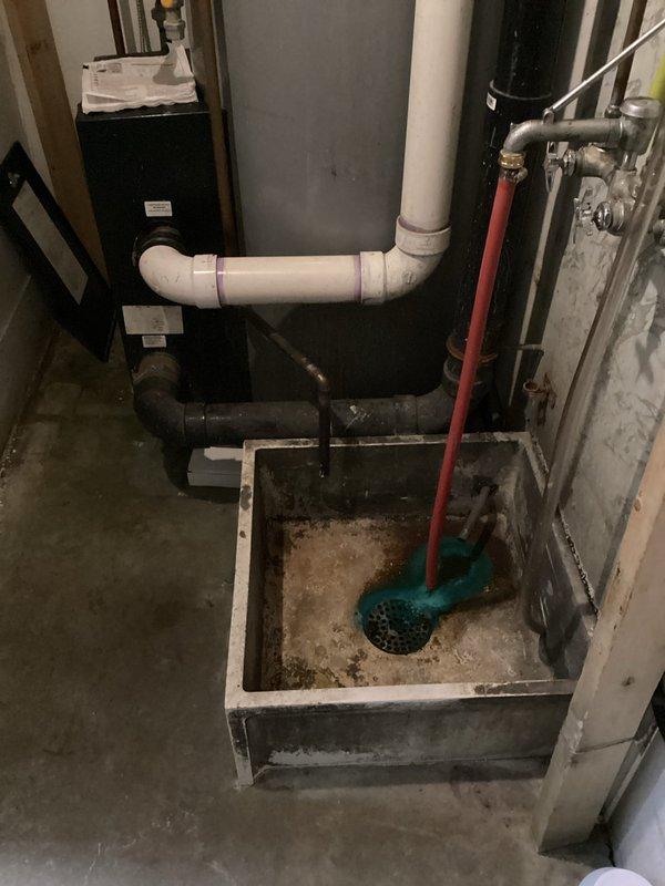 Conducted site assessment for replacement of 120-130 gallon water heater. Observed existing plumbing infrastructure including PVC drainage assembly and catch basin with turquoise strainer. Left instructions to contact Randy's cell phone when proceeding with installation.