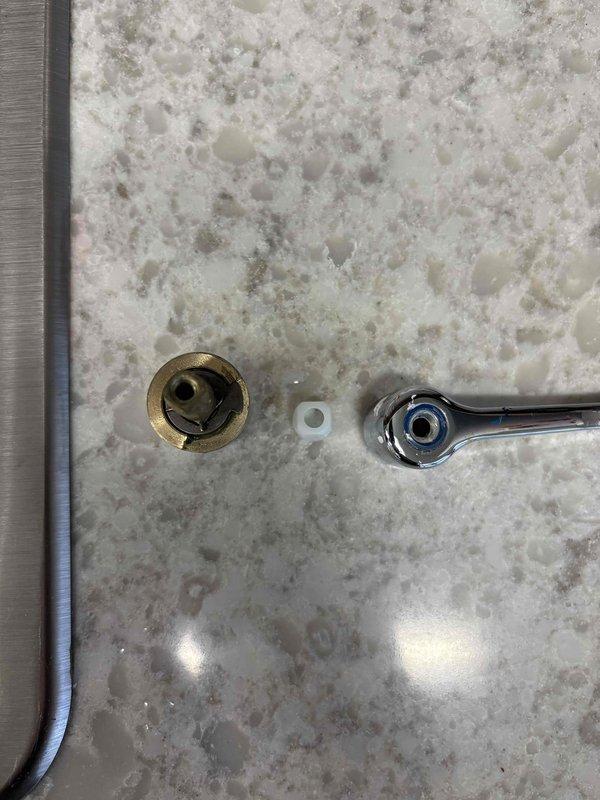 Diagnosed kitchen sink faucet that was continually running due to cracked hot and cold cartridges preventing proper water shutoff. Removed handles and inspected internal components, documenting the unmarked faucet model with photographs to source appropriate replacement parts for future repair.
