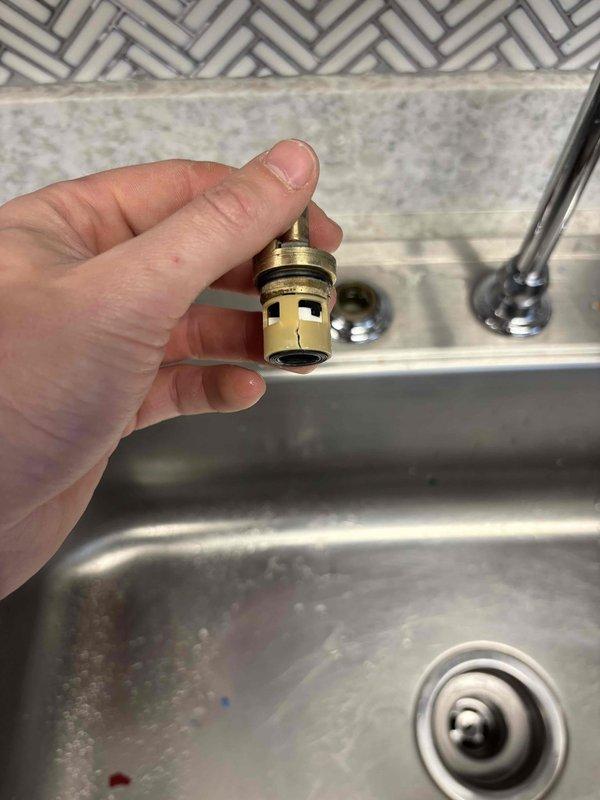 Diagnosed kitchen sink faucet that was continually running due to cracked hot and cold cartridges preventing proper water shutoff. Removed handles and inspected internal components, documenting the unmarked faucet model with photographs to source appropriate replacement parts for future repair.