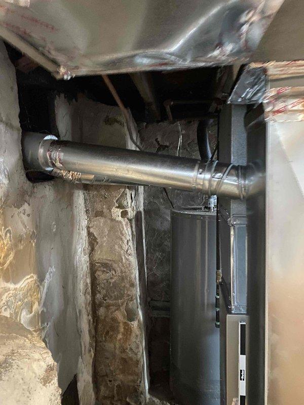 Completed installation of a Legacy 90% efficient gas furnace, requiring rotation of the unit 180 degrees to accommodate the narrow 17.5" space. Installed new R-drop, 1" filter rack, and drain pan. Patched a hole in the return air trunk and connected to existing 4" B-vent. All connections verified and system tested for proper operation.