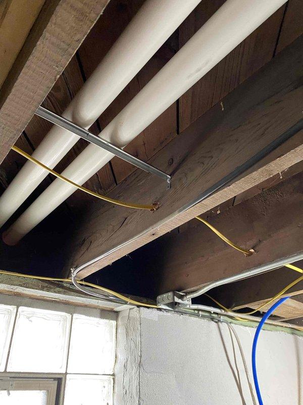 Completed corrections on HVAC installation following municipal inspection. Sealed humidifier elbow swivel joints, installed missing PVC vent support hanger near exterior wall, and properly labeled the furnace breaker as required. System now complies with all inspection requirements.