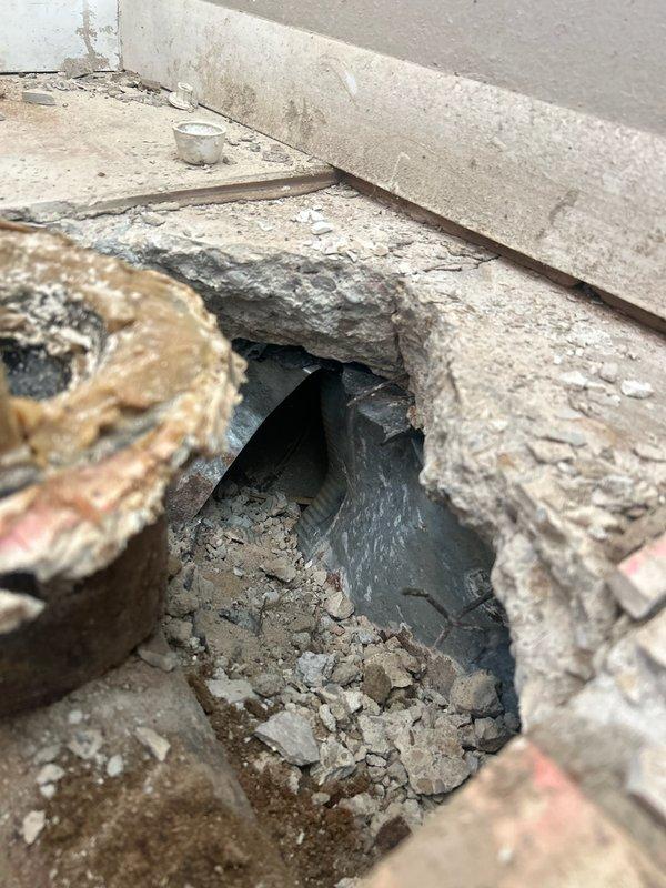 Responded to a time and materials service call where plumbing contractor had severed a duct during their work. Accessed the damaged area by excavating the floor near a doorframe, exposing the cut ductwork. Completed necessary repairs to restore proper functionality of the HVAC system after documenting the damage with photos.