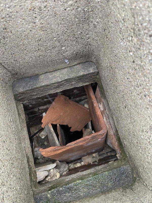 Inspected chimney structure in preparation for 4x45 liner installation. Documented current condition showing significant deterioration of metal components with visible rust and corrosion. Observed damaged wooden elements and debris accumulation within the chamber. Captured video documentation of the chimney top access point as requested before proceeding with liner installation.