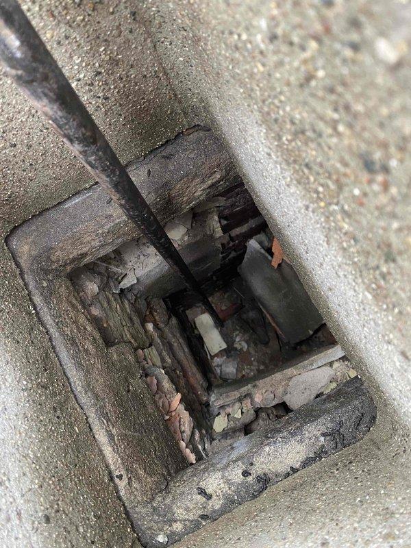 Inspected chimney structure in preparation for 4x45 liner installation. Documented current condition showing significant deterioration of metal components with visible rust and corrosion. Observed damaged wooden elements and debris accumulation within the chamber. Captured video documentation of the chimney top access point as requested before proceeding with liner installation.