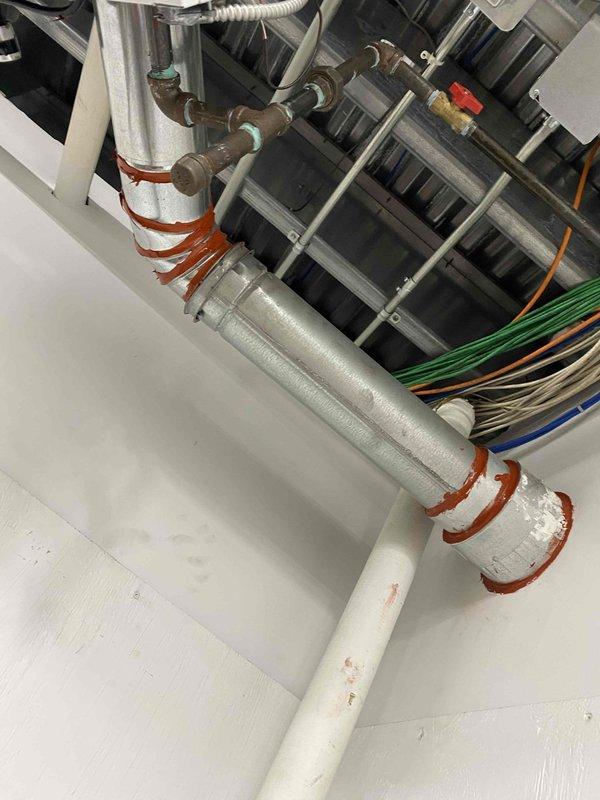 Completed code correction on unit heater by properly sealing all single wall vent joints per manufacturer's instructions for Cat. III configuration. Documented work with before/after photographs of the installation, ensuring proper venting through exterior wall panel with appropriate flange connections and sealed junction points.