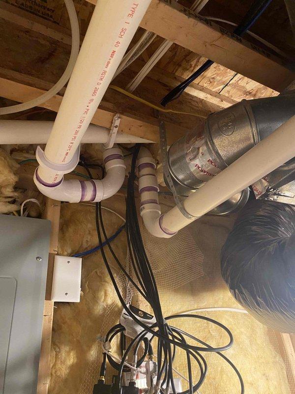 Relocated plumbing vent piping in attic space using 2" PVC materials. Installed new 2" vent kit with proper coupling connections and routing through existing framing to accommodate layout requirements. Protected work area with floor covering during installation and ensured proper integration with existing plumbing system.