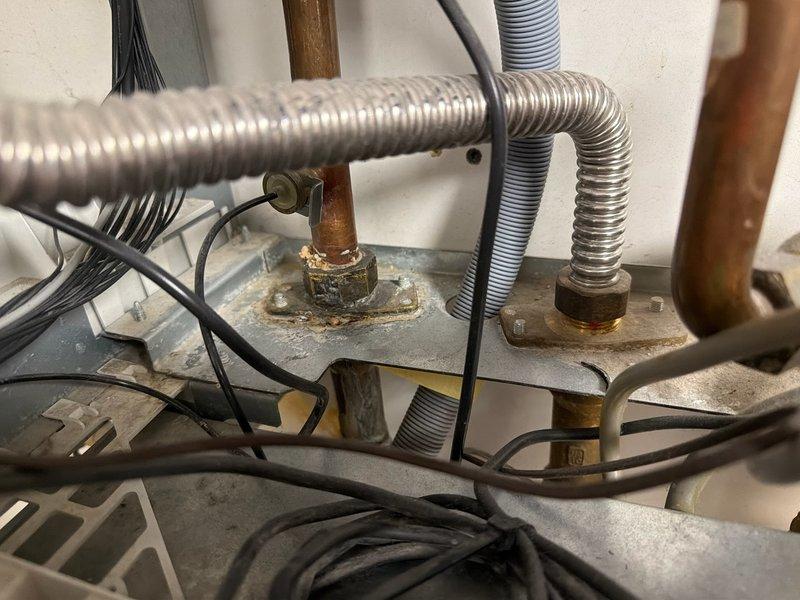 Responded to emergency service call for Triangle Tube boiler with active water leak in basement. Upon arrival, observed significant water discharge from boiler unit affecting surrounding area. Documented extensive corrosion on copper piping connections and deteriorated plumbing components with visible rust and oxidation throughout the system. Advised homeowner that Triangle Tube boilers are outside our service scope and instructed to shut off water supply to boiler immediately to prevent further water damage. Contacted management for authorization to decline service, photographed existing conditions showing corroded pipes, aged brass fittings, and compromised plumbing infrastructure for documentation purposes. Provided customer with information to submit photos and obtain repair quote from authorized service provider.