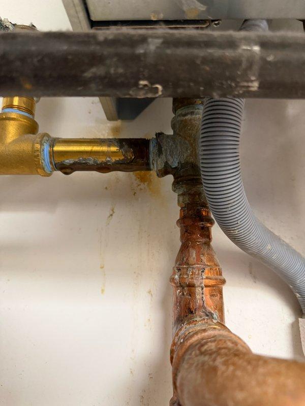Responded to emergency service call for Triangle Tube boiler with active water leak in basement. Upon arrival, observed significant water discharge from boiler unit affecting surrounding area. Documented extensive corrosion on copper piping connections and deteriorated plumbing components with visible rust and oxidation throughout the system. Advised homeowner that Triangle Tube boilers are outside our service scope and instructed to shut off water supply to boiler immediately to prevent further water damage. Contacted management for authorization to decline service, photographed existing conditions showing corroded pipes, aged brass fittings, and compromised plumbing infrastructure for documentation purposes. Provided customer with information to submit photos and obtain repair quote from authorized service provider.