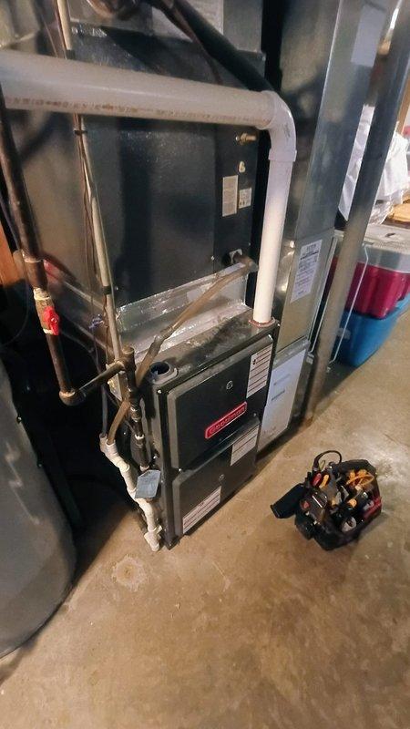 Performed scheduled air conditioning tune-up service on residential HVAC system located in basement utility room. Inspected furnace unit, associated ductwork, and PVC ventilation piping - all components in normal working condition with no visible damage. Additionally, customer reported unusually high hot water temperatures from water heater; documented issue for potential follow-up service.