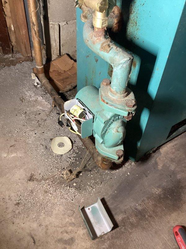 Responded to callback for boiler making loud popping sound accompanied by burning smell. Inspected control panel and found significant corrosion on pump assembly with evidence of water leakage. Identified failing circulation pump as source of noise and odor, replaced pump and tested system operation to confirm proper function.